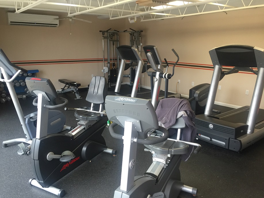 A fitness room with treadmills and bikes